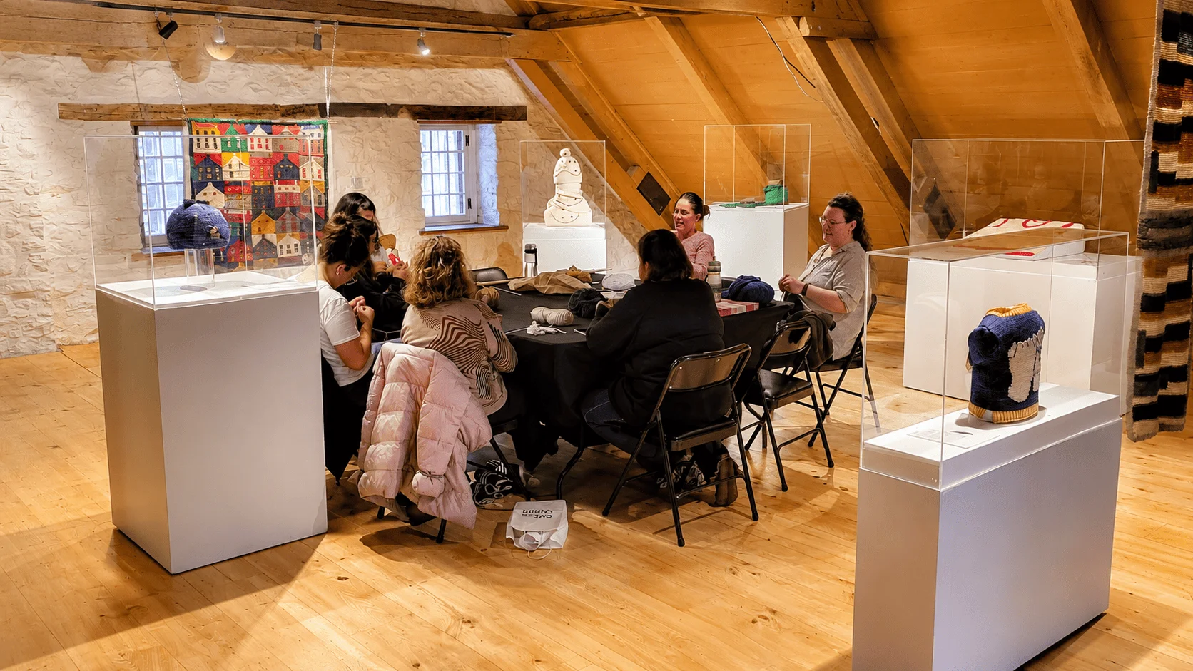 Participants réunis autour d'une table dans une salle d'exposition textile