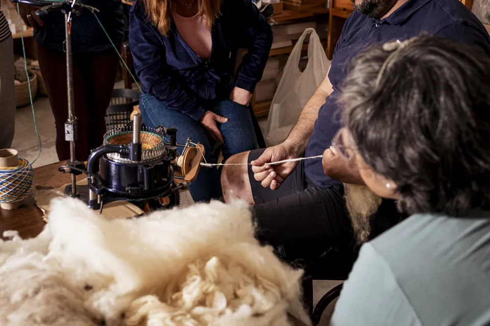 Gros plan sur les mains, la fibre et l’outil de filage